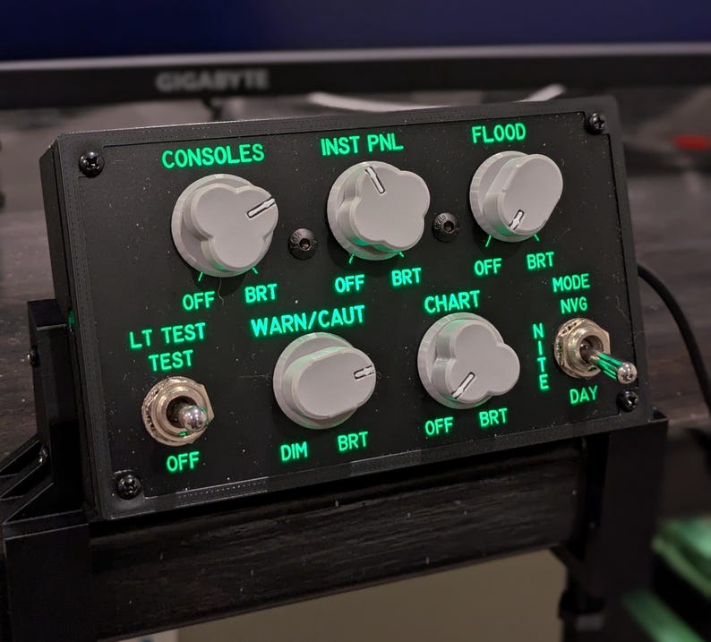 F-18 lighting panel with green backlit labels and gray knobs